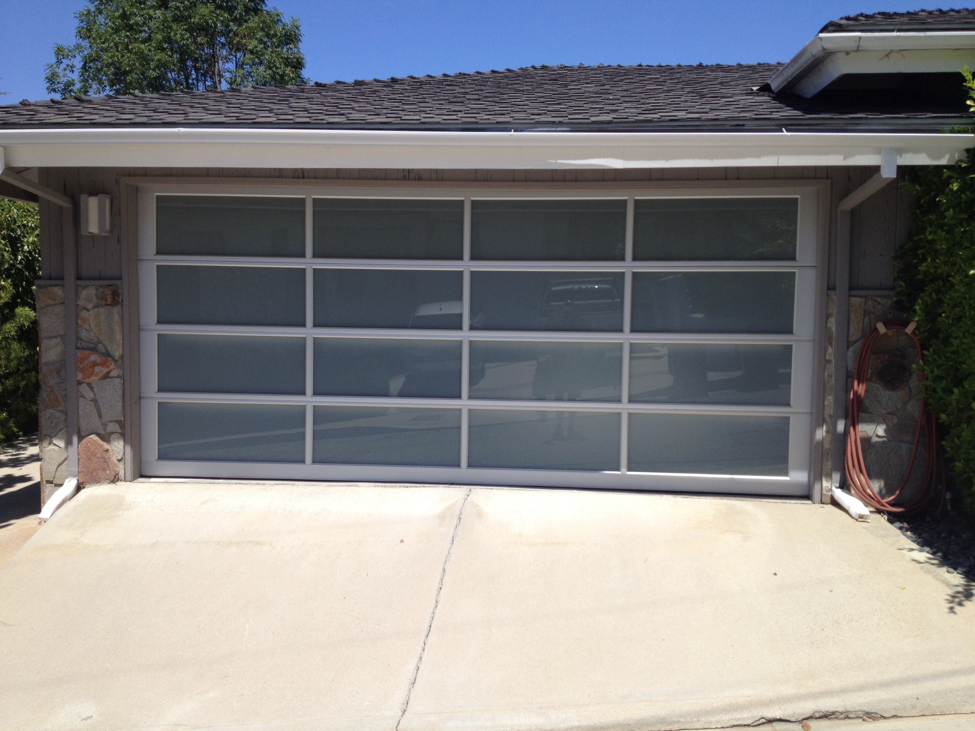 Full-view aluminum + frosted glass garage door installed by DoorWorks