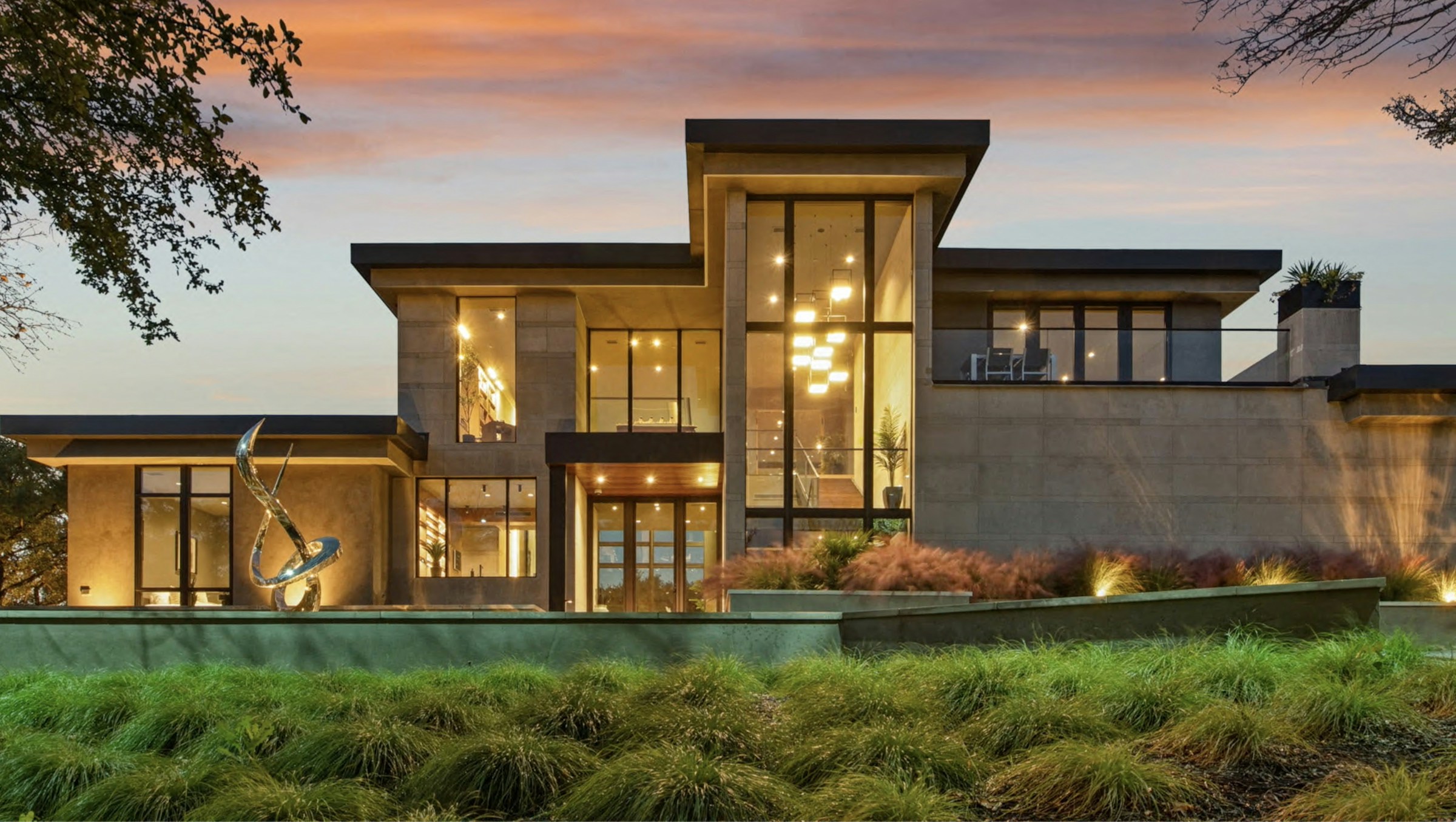 Modern glass garage door at dusk, illuminated from inside the garage